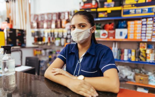 Young woman wearing face mask working in hardware store